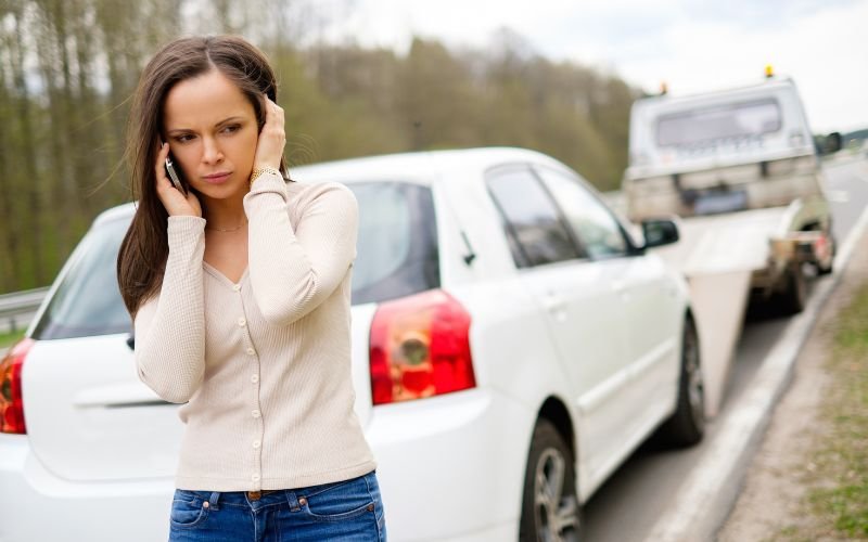 woman calling emergency contacts during towing